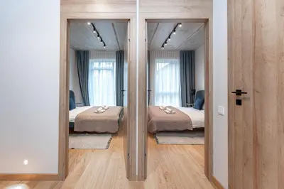 a bedroom with two beds and two mirrors at Brand New White Lotus Apartment 3 by Reside Baltic in Vilnius