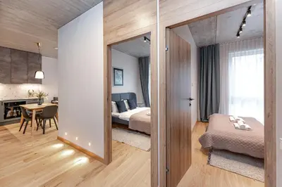 a bedroom with a bed and a table in a room at Brand New White Lotus Apartment 3 by Reside Baltic in Vilnius