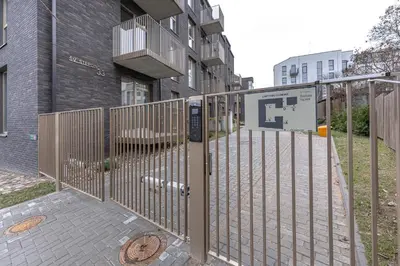 a gate in front of a building at Brand New White Lotus Apartment 3 by Reside Baltic in Vilnius