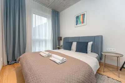 a bedroom with a large bed with two towels on it at Brand New White Lotus Apartment 3 by Reside Baltic in Vilnius