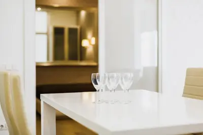 a white table with three wine glasses on it at Center Avenue Apartments in Vilnius