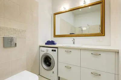 a bathroom with a washing machine and a mirror at Center Avenue Apartments in Vilnius