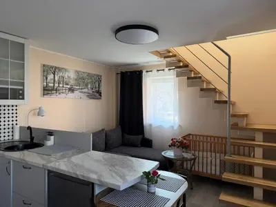 a kitchen and a living room with a staircase at Lampėdis in Kaunas