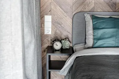 a bedroom with a bed and a clock on a table at Modern Urban loft in Vilnius