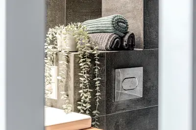 a bathroom with a vase with plants in it at Modern Urban loft in Vilnius