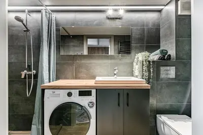 a bathroom with a washing machine and a sink at Modern Urban loft in Vilnius
