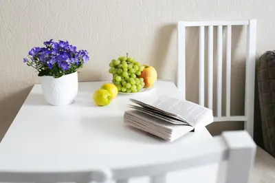a table with fruit and a book and a vase of flowers at Gedimino House in Vilnius