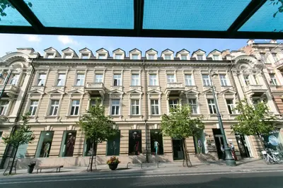 a large building on a street with trees in front at Gedimino House in Vilnius