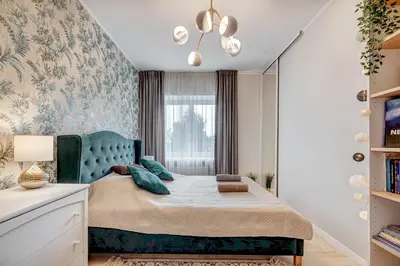 a bedroom with a bed with a blue headboard and a window at LuxCosy72m SelfCheckIn Huge2roms 9minOTown FreeParking in Vilnius