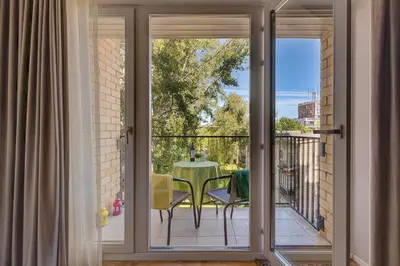 a sliding glass door leading to a balcony with a table at LuxCosy72m SelfCheckIn Huge2roms 9minOTown FreeParking in Vilnius