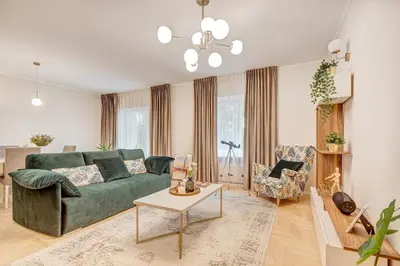 a living room with a green couch and a table at LuxCosy72m SelfCheckIn Huge2roms 9minOTown FreeParking in Vilnius