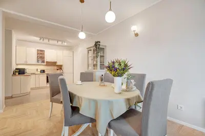 a kitchen and dining room with a table and chairs at LuxCosy72m SelfCheckIn Huge2roms 9minOTown FreeParking in Vilnius