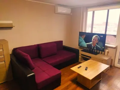 a living room with a red couch and a flat screen tv at ITAJA apartment 66 in Šiauliai