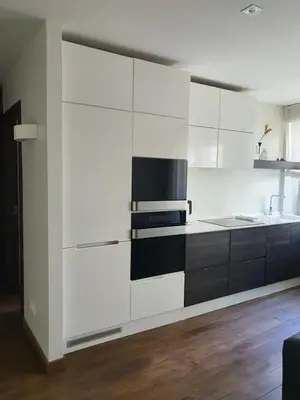 a white kitchen with black and white cabinets at Downtown Boulevard View Residence in Šiauliai