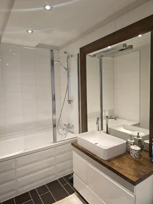 a bathroom with a sink and a tub and a mirror at Downtown Boulevard View Residence in Šiauliai