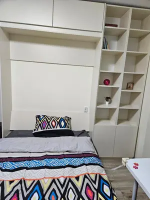 a small bedroom with a bed and shelves at HOME20GEDV in Vilnius
