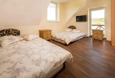 a bedroom with two beds and a tv at Sodyba ant ežero kranto pas Radvilą in Kiemeliai