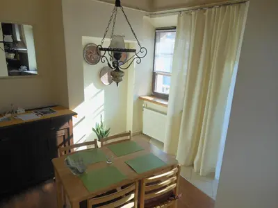 a dining room with a table and a chandelier at Daukanto Apartments in Vilnius