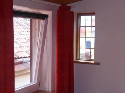 two windows with red curtains in a room at Daukanto Apartments in Vilnius