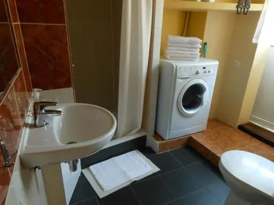 a bathroom with a washing machine and a sink at Daukanto Apartments in Vilnius