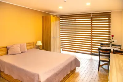 a bedroom with a bed and a table and a chair at NK apartments in Druskininkai