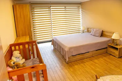 a bedroom with a bed and a teddy bear in a chair at NK apartments in Druskininkai