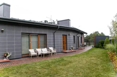 a gray house with chairs and a patio at NK apartments in Druskininkai