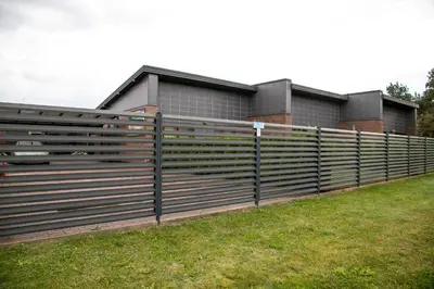 a fence in front of a house at NK apartments in Druskininkai