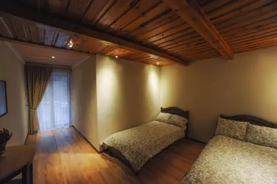a bedroom with two beds and a wooden ceiling at Karčema Ružava in Molainiai