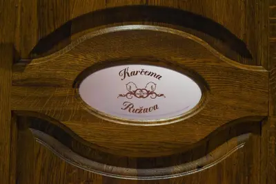 a wooden table with a sign on top of it at Karčema Ružava in Molainiai
