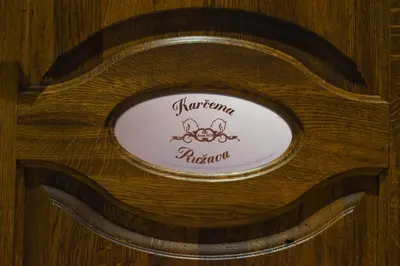 a sign on a wooden chair with a monkey on it at Karčema Ružava in Molainiai