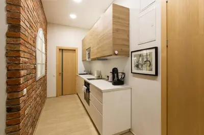 a kitchen with white counters and a brick wall at L studio in Kaunas