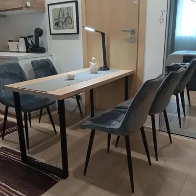 a table and chairs in a room with a kitchen at L studio in Kaunas
