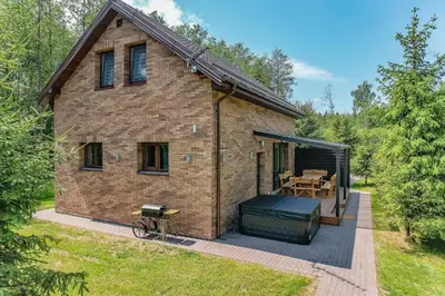 a brick house with a grill and a patio at Zalesossodyba in Purnuškis