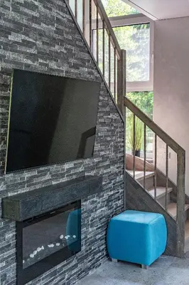 a living room with a large tv on a brick wall at Zalesossodyba in Purnuškis
