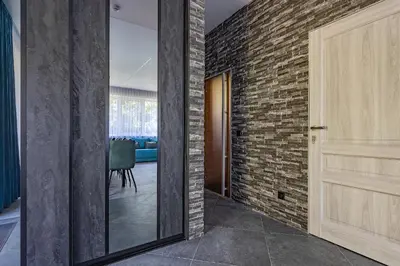 a hallway with a door and a brick wall at Zalesossodyba in Purnuškis