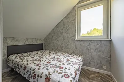 a bedroom with a bed and a window at Zalesossodyba in Purnuškis
