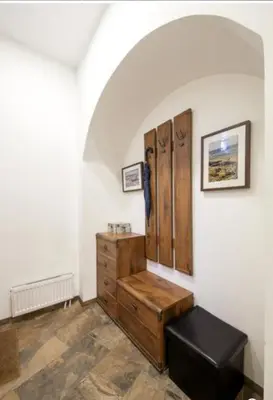 a room with a wooden dresser and a black stool at HaPPy iNN ToTo Old Town, Self check, Parking in the yard, in Vilnius