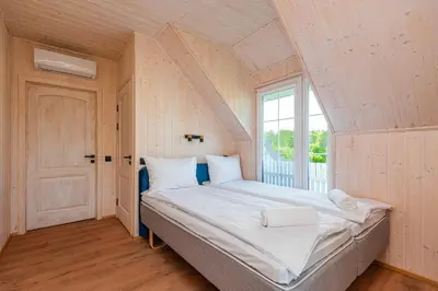 a large bed in a room with a window at Namelis ant ežero kranto 