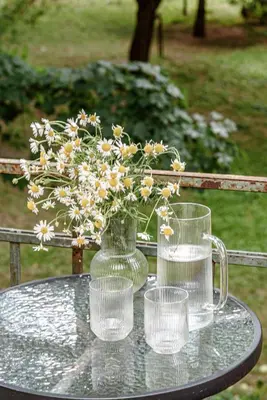 a glass vase with flowers in it on a table at Jacuzzi apartments x Free parking x SELF CHECK-IN 24x7 by H&H in Vilnius