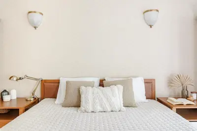 a bedroom with a bed with white sheets and pillows at Jacuzzi apartments x Free parking x SELF CHECK-IN 24x7 by H&H in Vilnius