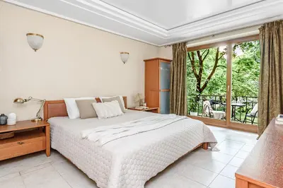 a bedroom with a white bed and a large window at Jacuzzi apartments x Free parking x SELF CHECK-IN 24x7 by H&H in Vilnius