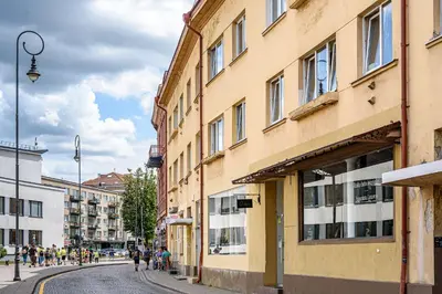 a city street with buildings and people walking on the street at Jacuzzi apartments x Free parking x SELF CHECK-IN 24x7 by H&H in Vilnius