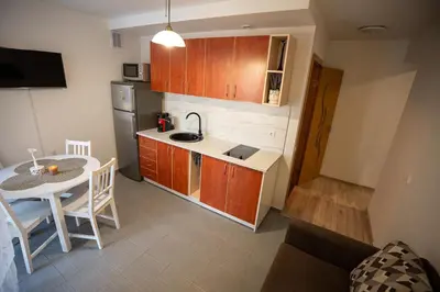 a kitchen with a table and a small kitchen with a sink at Loft apartment in Druskininkai