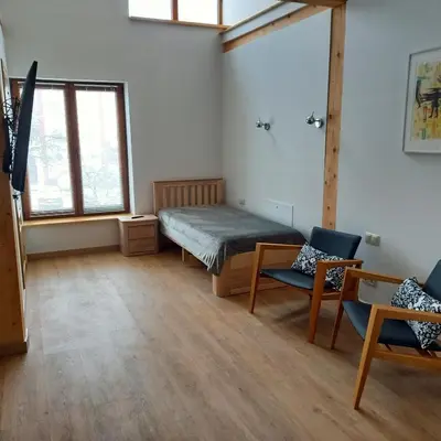 a bedroom with a bed and two chairs in a room at S Neries 19 apartamentai su parkingu in Šiauliai