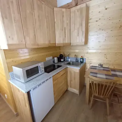 a small kitchen with a microwave and a sink at S Neries 19 apartamentai su parkingu in Šiauliai