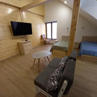 a room with two beds and a flat screen tv at S Neries 19 apartamentai su parkingu in Šiauliai