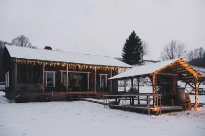 a cabin with christmas lights on it in the snow at Daugirdėnų sodyba in Didžiuliai