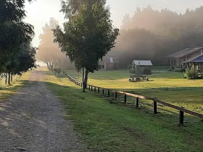 a dirt road next to a field with a fence at Daugirdėnų sodyba in Didžiuliai
