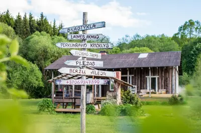 a street sign with many signs in front of a building at Daugirdėnų sodyba in Didžiuliai